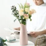 Elegant ceramic vase with fresh flowers on a table, modern home decor.