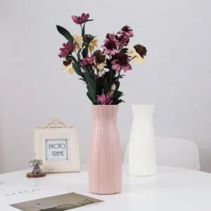 Elegant pink and white ceramic vases with flowers on a modern table.