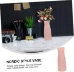 Nordic style pink vase with flowers on a marble surface, modern home decor.