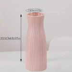 Elegant pink ceramic vase with ribbed texture, perfect for modern home decor.