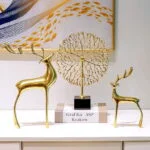 Modern gold deer sculptures and abstract wall art in a luxury home setting.