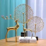 Gold decorative deer and tree sculptures on a wooden table, modern home decor.