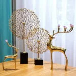 Elegant gold deer and tree sculptures on a wooden table, modern home decor.