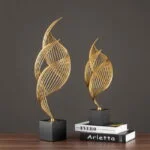 Modern gold decorative sculptures on black bases, perfect for luxury home decor.