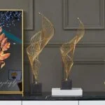 Modern gold decorative sculptures on a black and white base, luxury home decor.