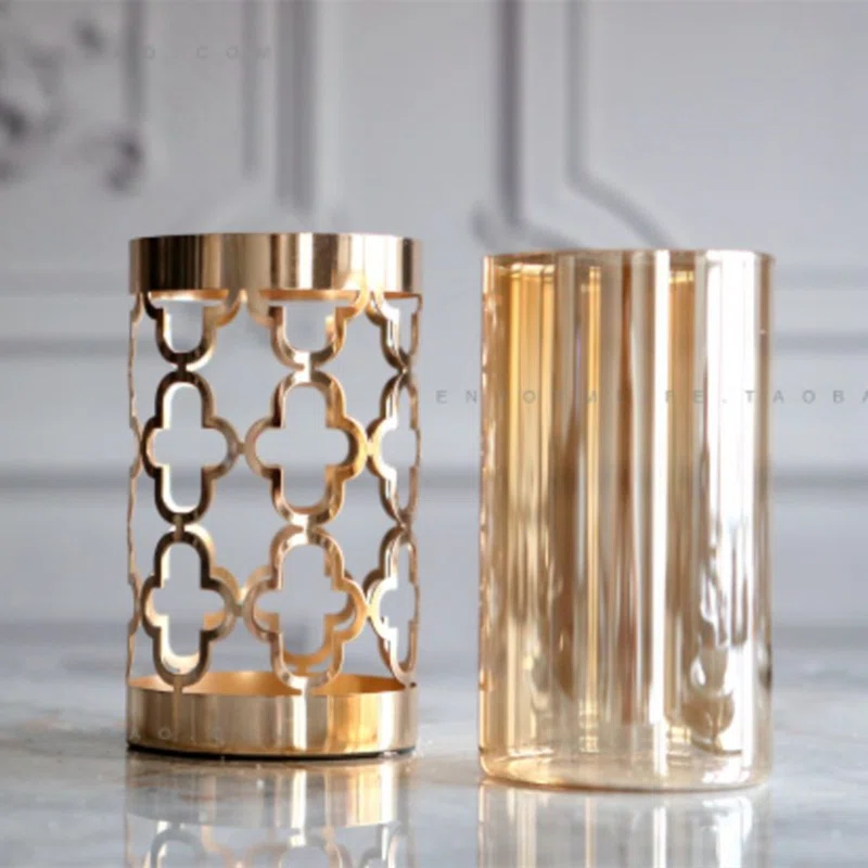 Elegant gold decorative candle holders on a marble surface, modern home decor.