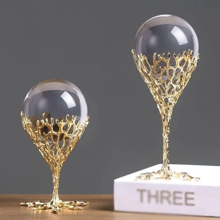Elegant gold decorative ornaments with crystal spheres on a wooden surface.