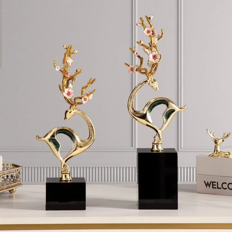 Elegant gold deer sculptures with floral antlers on black bases for modern home decor.
