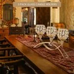 Elegant glass candle holders on a wooden dining table in a luxurious home setting.