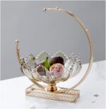 Elegant decorative fruit bowl with gold accents on a marble table.