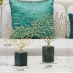 Gold decorative tree sculptures on marble bases for modern home decor.