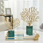 Luxury gold coral sculptures on a decorative tray in a modern living room.