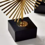 Gold decorative sculpture on black base, modern home decor accessory.