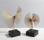 Modern gold decorative sculptures on black bases for luxury home decor.