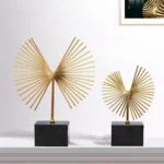 Gold decorative sculptures on a black base, modern home decor.