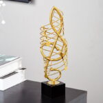 Gold decorative sculpture on black base, modern home decor accessory.