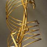 Gold decorative sculpture with modern design and intricate curves.