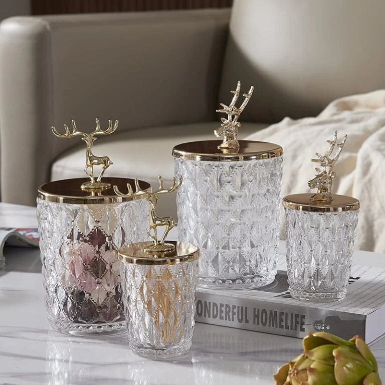 Elegant crystal jars with gold deer lids on a modern living room table.