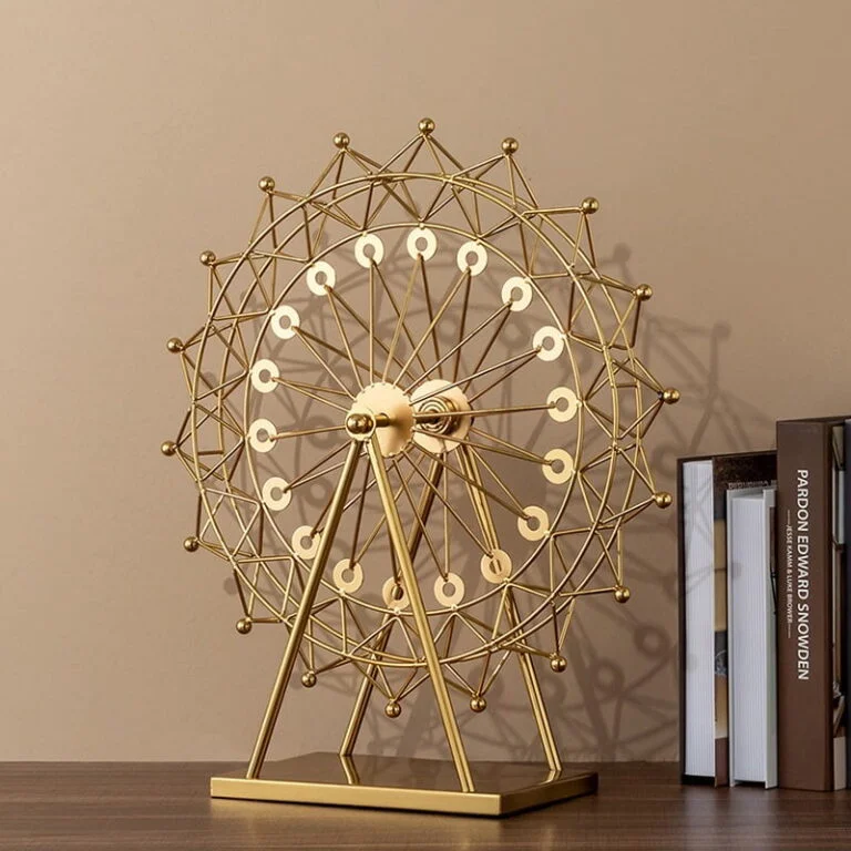 Gold Ferris wheel sculpture on a table with books, modern home decor accessory.