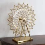 Gold decorative Ferris wheel sculpture on a wooden table, modern home decor accent.