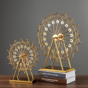 Gold decorative Ferris wheel sculptures on books, modern home decor.