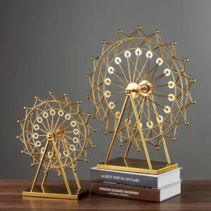 Gold decorative Ferris wheel sculptures on books, modern home decor.
