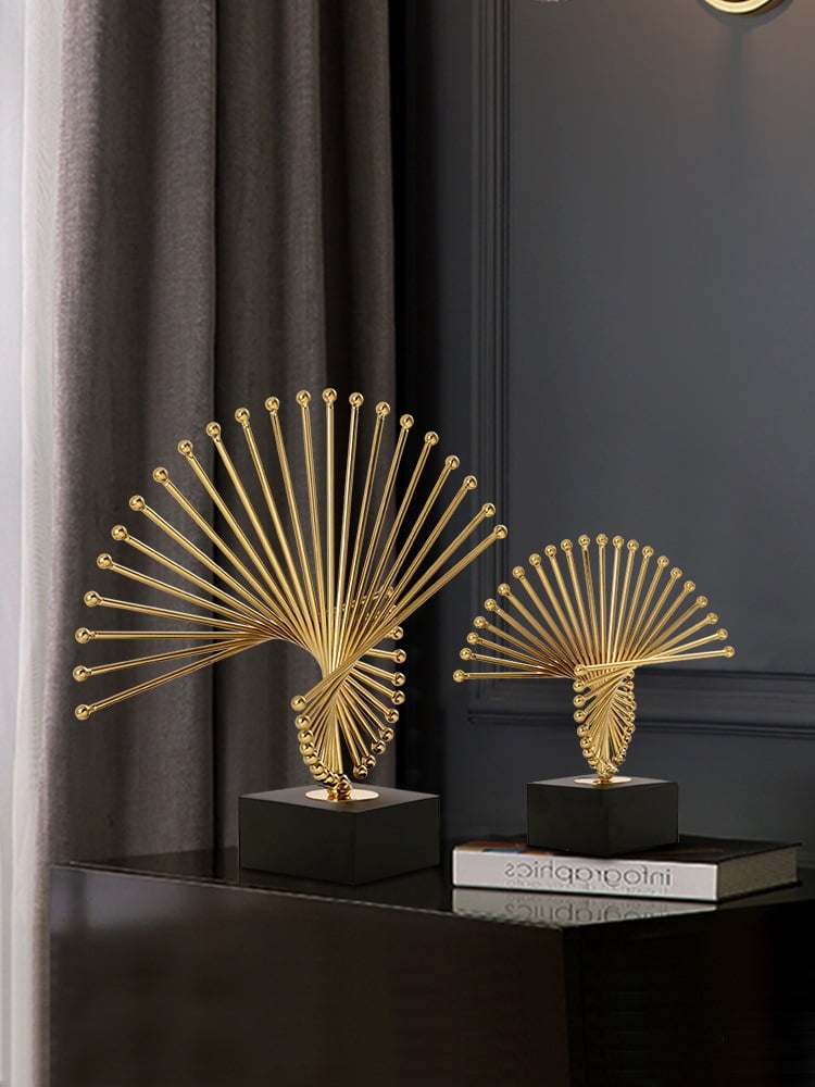 Elegant gold decorative sculptures on a black table in a modern home setting.