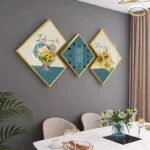 Modern dining room with geometric wall art and clock, featuring floral designs and gold frames.