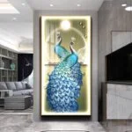Illuminated wall art featuring two peacocks with vibrant blue feathers in a modern living room setting.