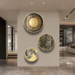 Modern luxury wall art with gold and black circular designs in a contemporary living room.