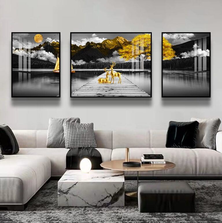 Modern living room with framed wall art featuring a serene lake and deer, accented with gold tones.