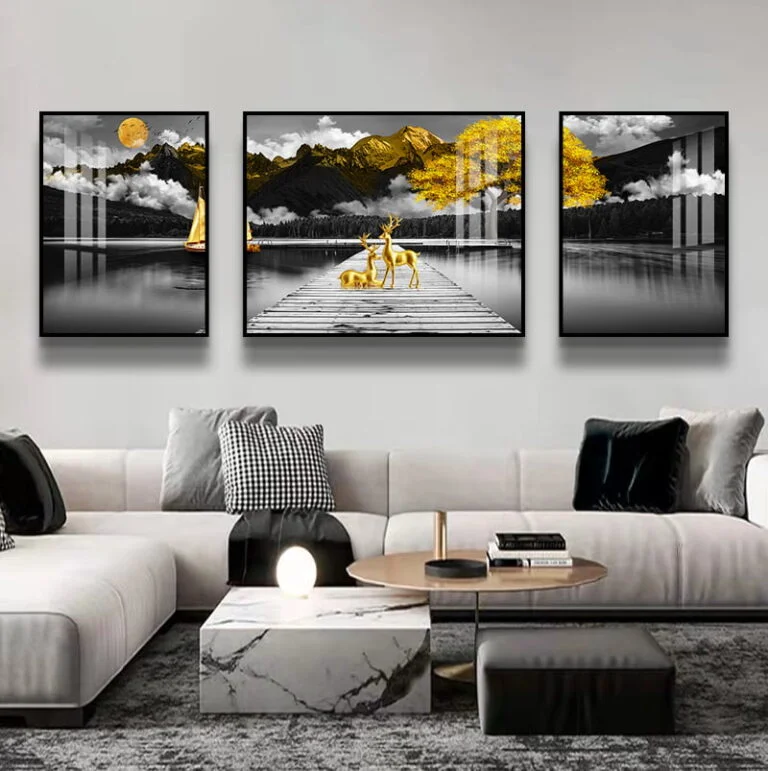 Modern living room with framed wall art featuring a serene lake and deer, accented with gold tones.