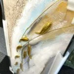 Modern luxury wall art with gold accents and abstract design in a protective frame.