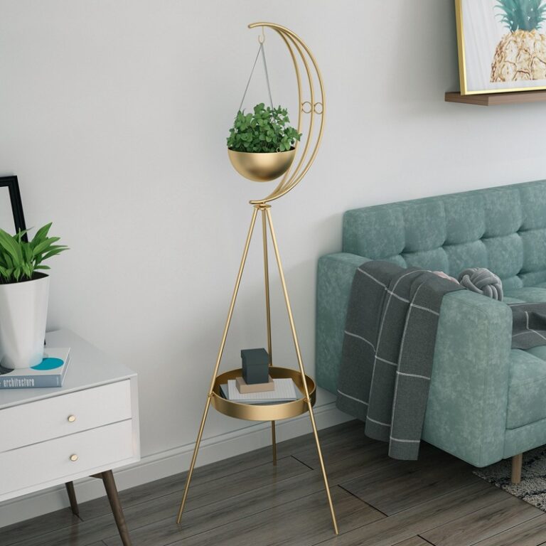 Modern gold planter stand with crescent moon design in a stylish living room.