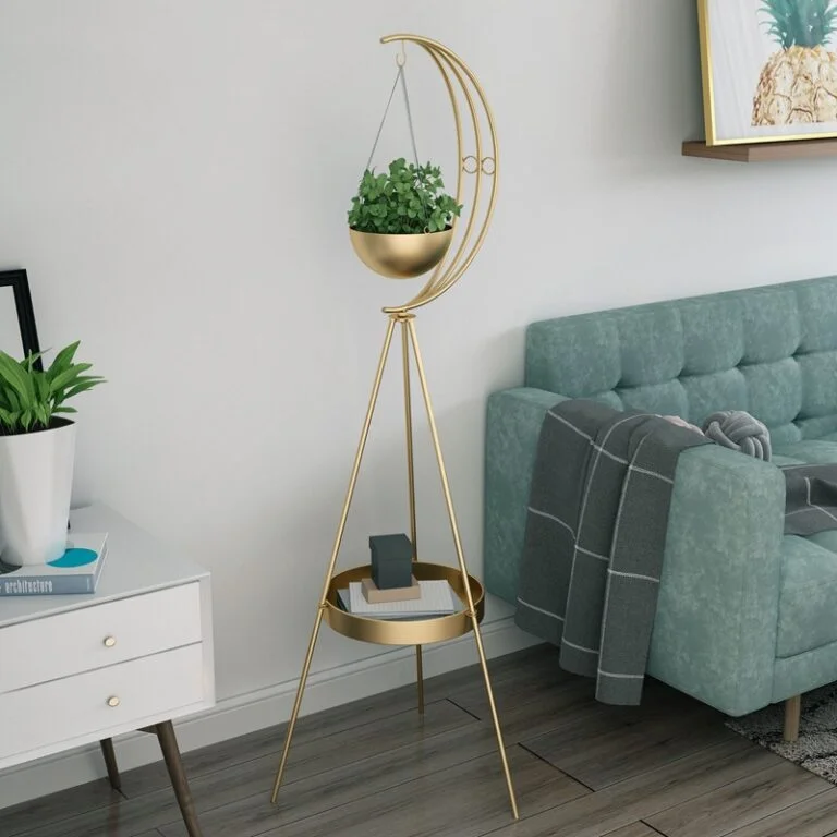 Modern gold planter stand with crescent moon design in a stylish living room.