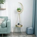 Modern gold indoor planter with crescent design and small table in a stylish living room.