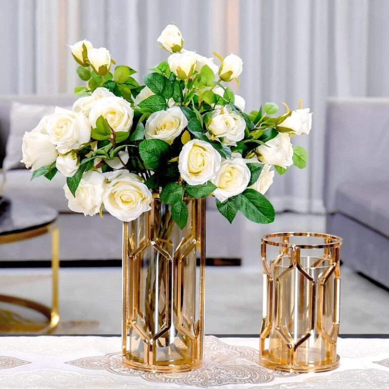 Elegant gold vases with white roses in a modern living room setting.