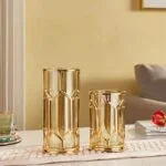 Elegant gold decorative vases on a table in a modern living room setting.