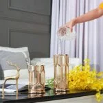 Modern luxury home decor with gold vases and decorative deer sculpture on a table.