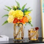 Elegant gold decorative vases with vibrant flowers, perfect for modern luxury home decor.