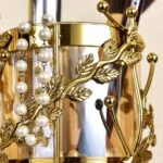 Elegant gold decorative vase with leaf design and pearl accents, perfect for luxury home decor.