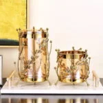 Elegant gold decorative vases with intricate leaf design on a marble base.