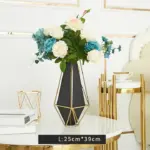 Elegant geometric vase with flowers on a modern luxury table.