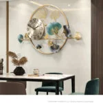 Modern luxury wall clock with decorative metal leaves in a dining room setting.