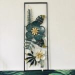 Modern floral metal wall art with green and gold accents in a rectangular frame.