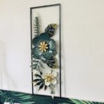 Modern floral metal wall art with green and gold accents in a rectangular frame.