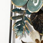 Modern decorative wall art with metal leaves and floral design in green and gold.
