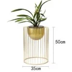 Gold metal planter with green plant, modern home decor accessory.
