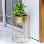 Modern gold metal planter with green plant, perfect for luxury home decor.