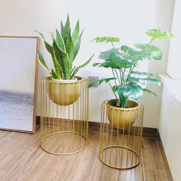 Modern gold metal planters with green plants in a bright room.